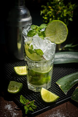 Refreshing mint cocktail mojito with  lime, cold drink or beverage with ice on black background