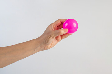 Pink plastic ball in hand, white background