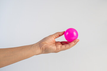 Pink plastic ball in hand, white background