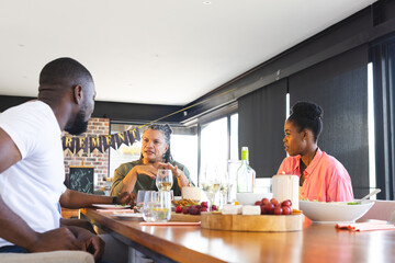 Family enjoying retirement celebration with wine and snacks at home