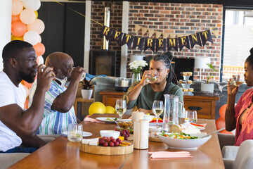 Family celebrating retirement, enjoying drinks and food at home with decorations