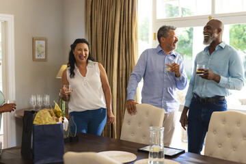 Seniors enjoying drinks and laughter at home during joyful celebration