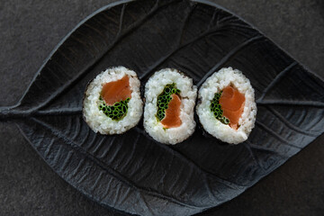 Zestaw sushi na czarnej tacy w kształcie liścia Assorted sushi on a black leaf-shaped tray