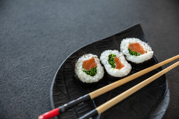 Zestaw sushi na czarnej tacy w kształcie liścia Assorted sushi on a black leaf-shaped tray