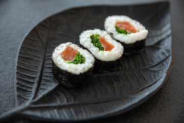 Zestaw sushi na czarnej tacy w kształcie liścia Assorted sushi on a black leaf-shaped tray