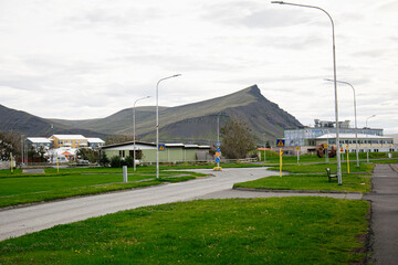 Fototapeta premium Quiet suburban landscape with mountain scenery in Akranes, Iceland under overcast sky