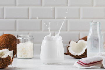 A splash of coconut milk in a mug with fresh coconut. Alternative milk, plant milk.