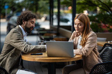 Fototapeta premium Business people working on laptop at outdoor cafe