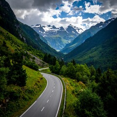 Obraz premium Mountain road winding through lush valley