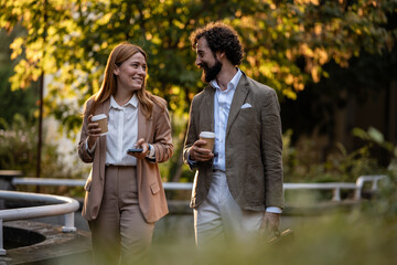 Business people walking and talking during coffee break outdoors