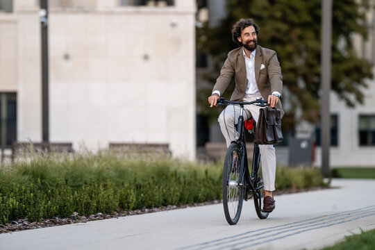 Businessman riding bicycle in urban setting, embracing sustainable commute