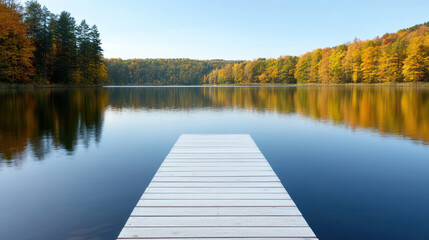 Serene dock extends over calm lake surrounded by vibrant autumn foliage