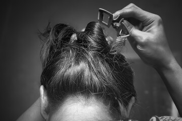 Back View of Person Tying or Clipping Hair in Casual Style