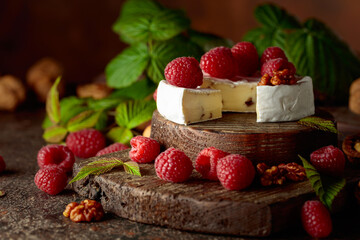 Camembert cheese with fresh raspberries and walnuts.