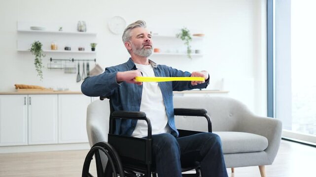 Mature Caucasian man in wheelchair performing stretching exercises using rubber resistance bands within contemporary home environment. Demonstrates independence, fitness focus, and a disciplined - Powered by Adobe