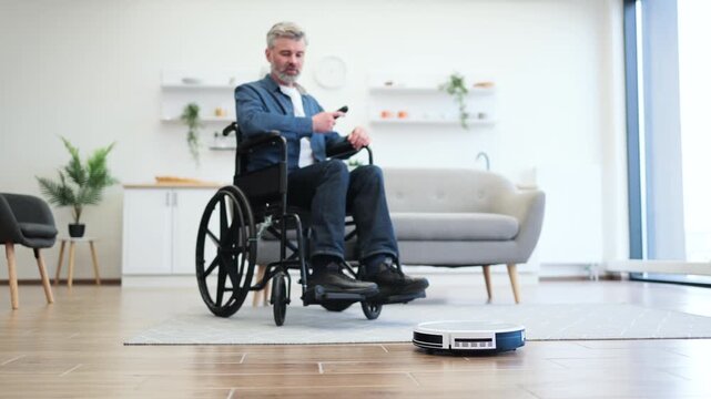 Senior man in wheelchair cleaning modern living room floor using robot vacuum, emphasizing independence aided by technology and innovation, reflecting concepts of smart home, accessibility