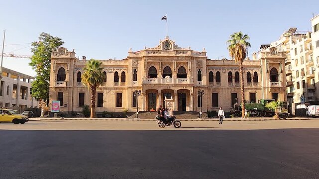 Damascus, Syria
08.08.2025
Historic Hijaz Railway station with Islamic architectural design and the new Syrian revolution flag waving above. Iconic Middle Eastern travel and cultural heritage landmark