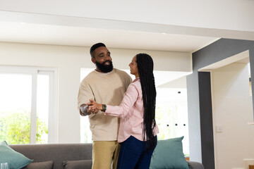 African American couple dancing happily at home, enjoying quality time together © wavebreak3
