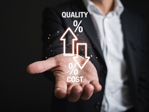 Businessman holding open palm with glowing quality increase and cost decrease icons finance strategy