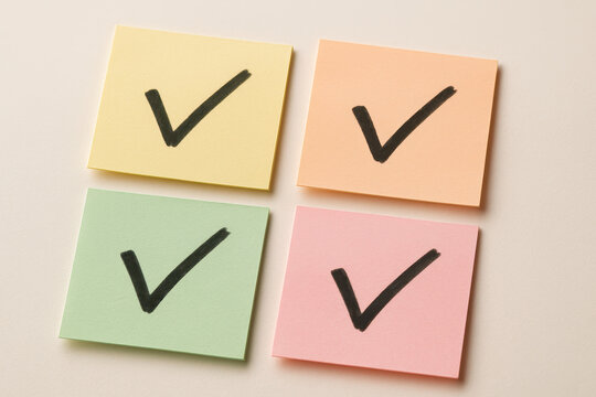 Checklist and to do list concept with colorful sticky notes featuring bold check marks representing completed task list and organized planning for productivity and efficiency