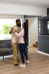 African American couple dancing together at home, enjoying joyful moment © wavebreak3