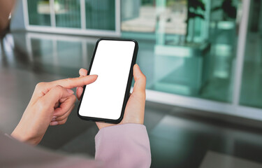 Close-up of a business woman's hand holding smartphone with blank white screen with clipping path for mockup marketing advertising and presentations