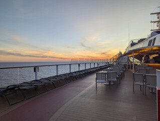At sea 2025.09.13. - Open deck with sunbeds and chairs during sunset onboard a cruise ship