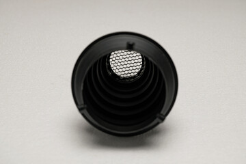 Black cylindrical object with mesh screen