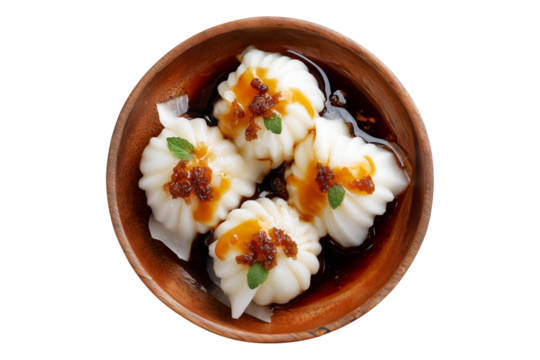 Steamed Faikakai dumplings topped with soy-based glaze, coconut syrup and sesame seeds served in wooden bowl isolated on white transparent background, concept of Polynesian cuisine