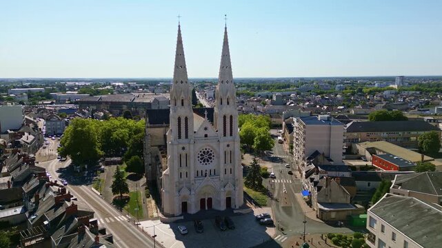 Smooth panoramic drone fly around the two bell towers Church of Saint-Andr&eacute; in Chateauroux, Chateauroux, Centre-Val de Loire, France.