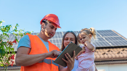 Family with solar panels discussing installation with engineer