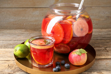 Tasty punch and fruits on wooden table, closeup. Refreshing drink