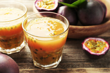 Tasty passion fruit drink and fresh fruits on wooden table, closeup