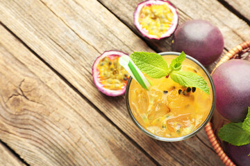 Tasty passion fruit drink with mint and fresh fruits on wooden table, flat lay. Space for text