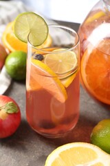 Punch and fresh fruits on grey table, closeup. Refreshing drink