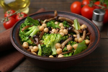 Delicious salad with shimeji mushrooms, chickpeas and broccoli served on wooden table, closeup