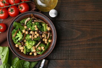 Delicious salad with shimeji mushrooms, chickpeas and broccoli served on wooden table, flat lay. Space for text