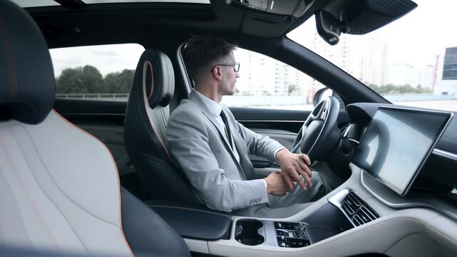 A man in a suit is driving a car and it is in a good mood