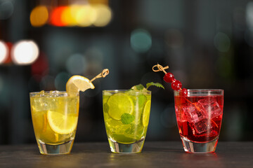 Glasses of alcoholic cocktails on table against blurred background