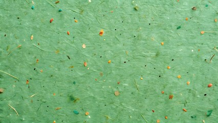 Textured green handmade paper with visible fibers and flecks for crafting and art