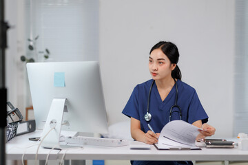 Female doctor working with medical records on computer in clinic