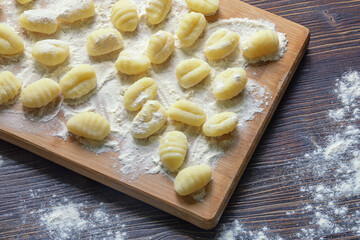 Balkan cuisine. Njoke , potato dumpling on wooden cutting board. Rustic table