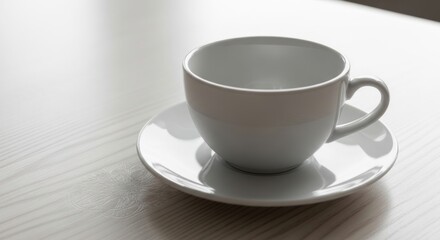 Fototapeta premium Empty white coffee cup and saucer on light wooden table