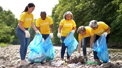 Group of Diverse Volunteers Collecting Trash by River in Yellow T Shirts - Powered by Adobe