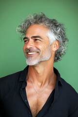 Fototapeta premium A strong and graceful male displaying confidence. Green solid ba
