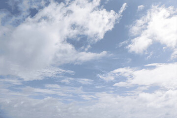 A beautiful blue sky filled with scattered white cumulus and cirrus clouds on a bright, sunny day.