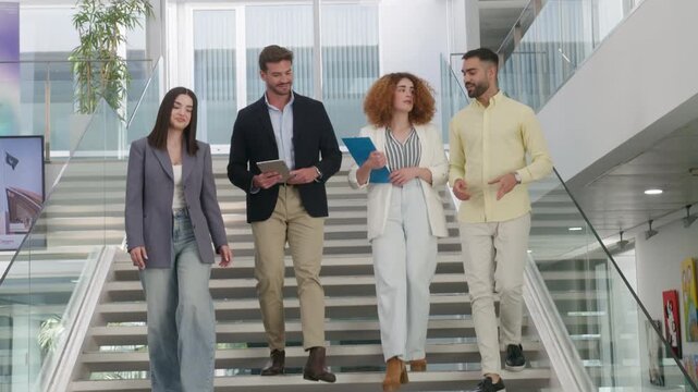 Businesspeople walking downstairs in modern office