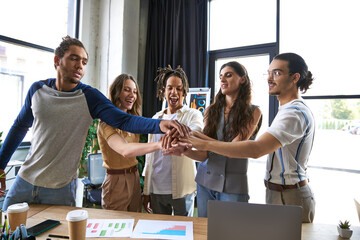 Young stylish coworkers collaborate and celebrate success in modern office setting