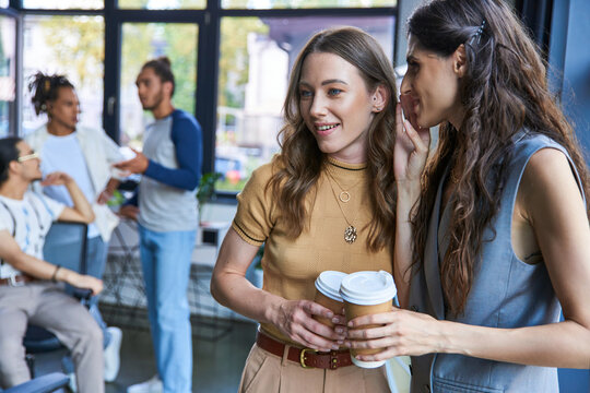 Young stylish coworkers engaging in vibrant discussions at a modern office space