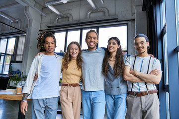 Stylish coworkers sharing a joyful moment in a vibrant office space during a workday